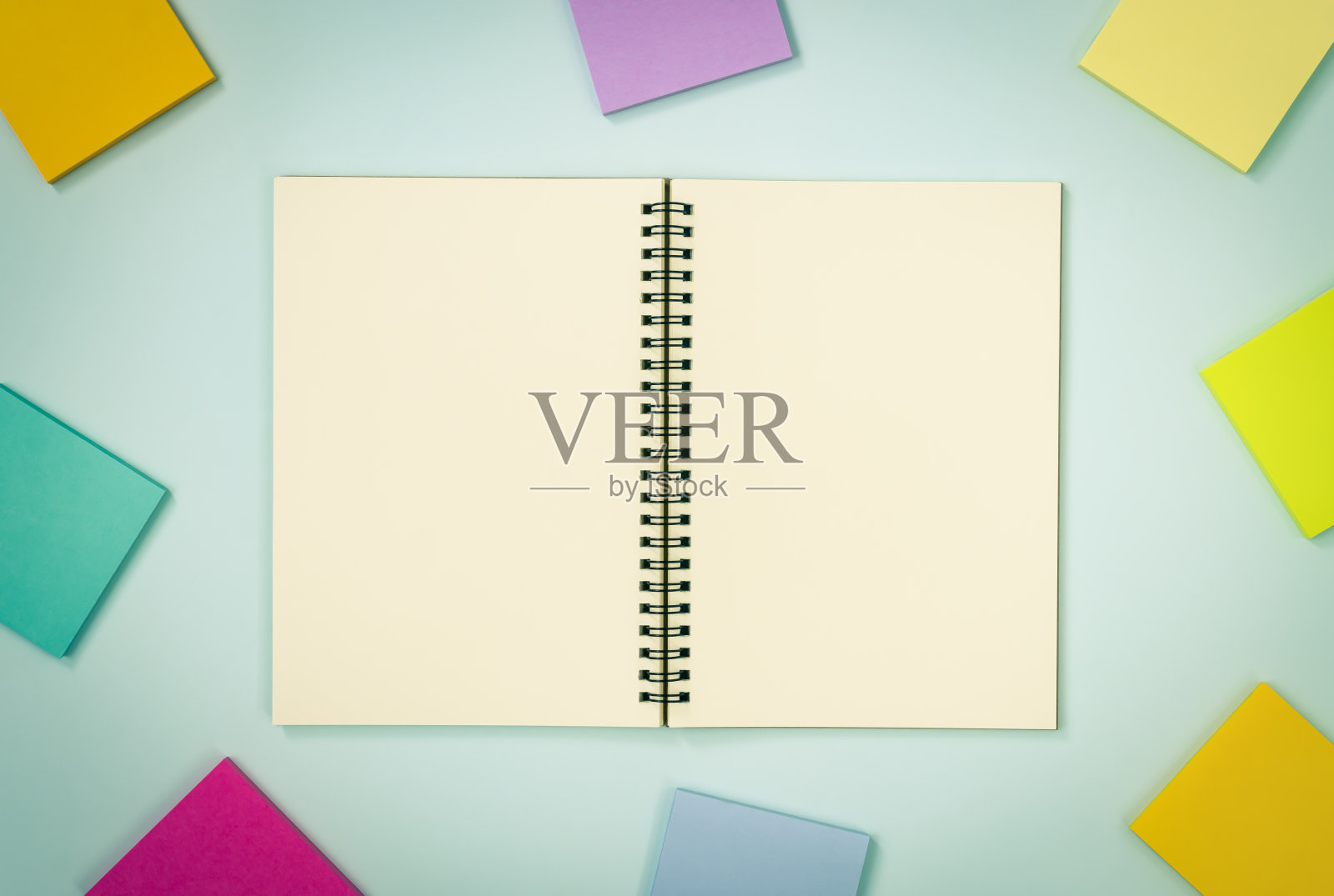 顶级桌子螺旋式笔记本和贴在粉彩极简背景在复古色调照片摄影图片