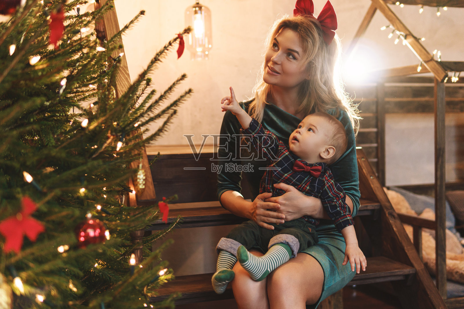 快乐的妈妈和她可爱的小儿子正在庆祝圣诞节或新年。照片摄影图片