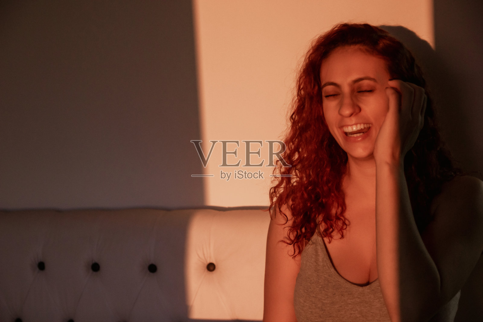 日落时分，红发女孩在自己的房间里放松照片摄影图片