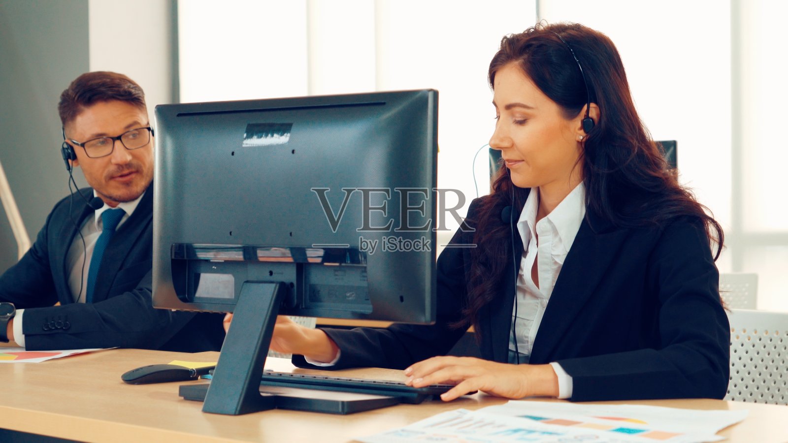 商务人员戴着耳机在办公室工作照片摄影图片