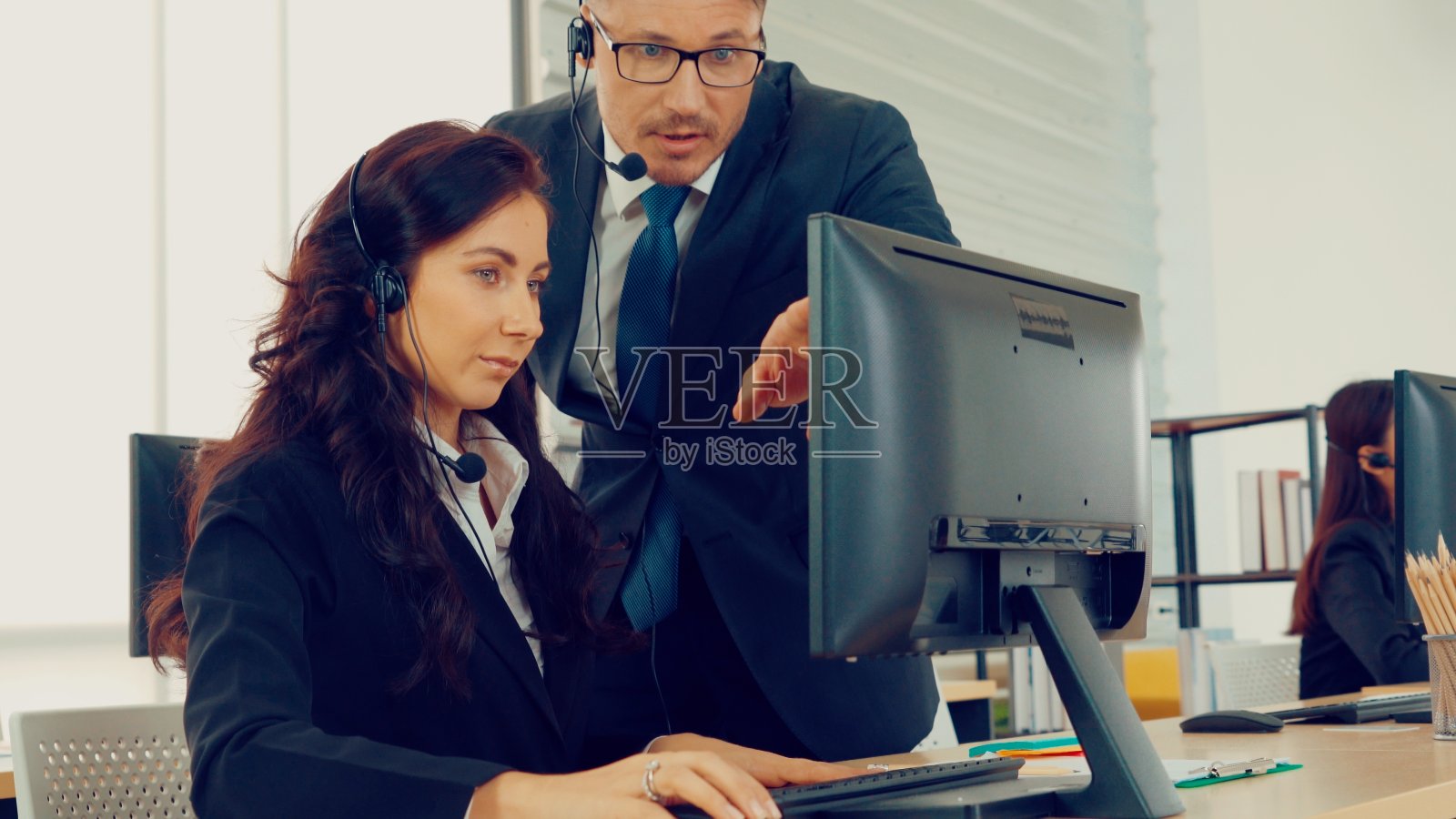 商务人员戴着耳机在办公室工作照片摄影图片