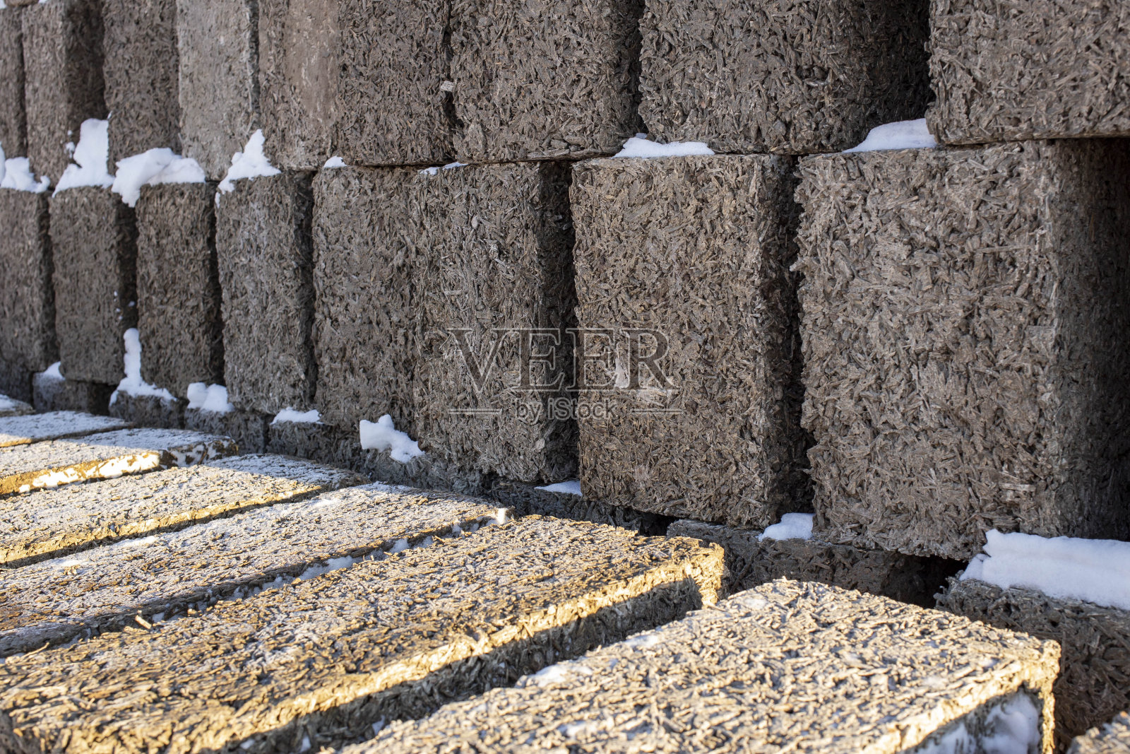 在蓝天的映衬下，大块的烟煤堆在一起，前景和背景用散景效果模糊照片摄影图片