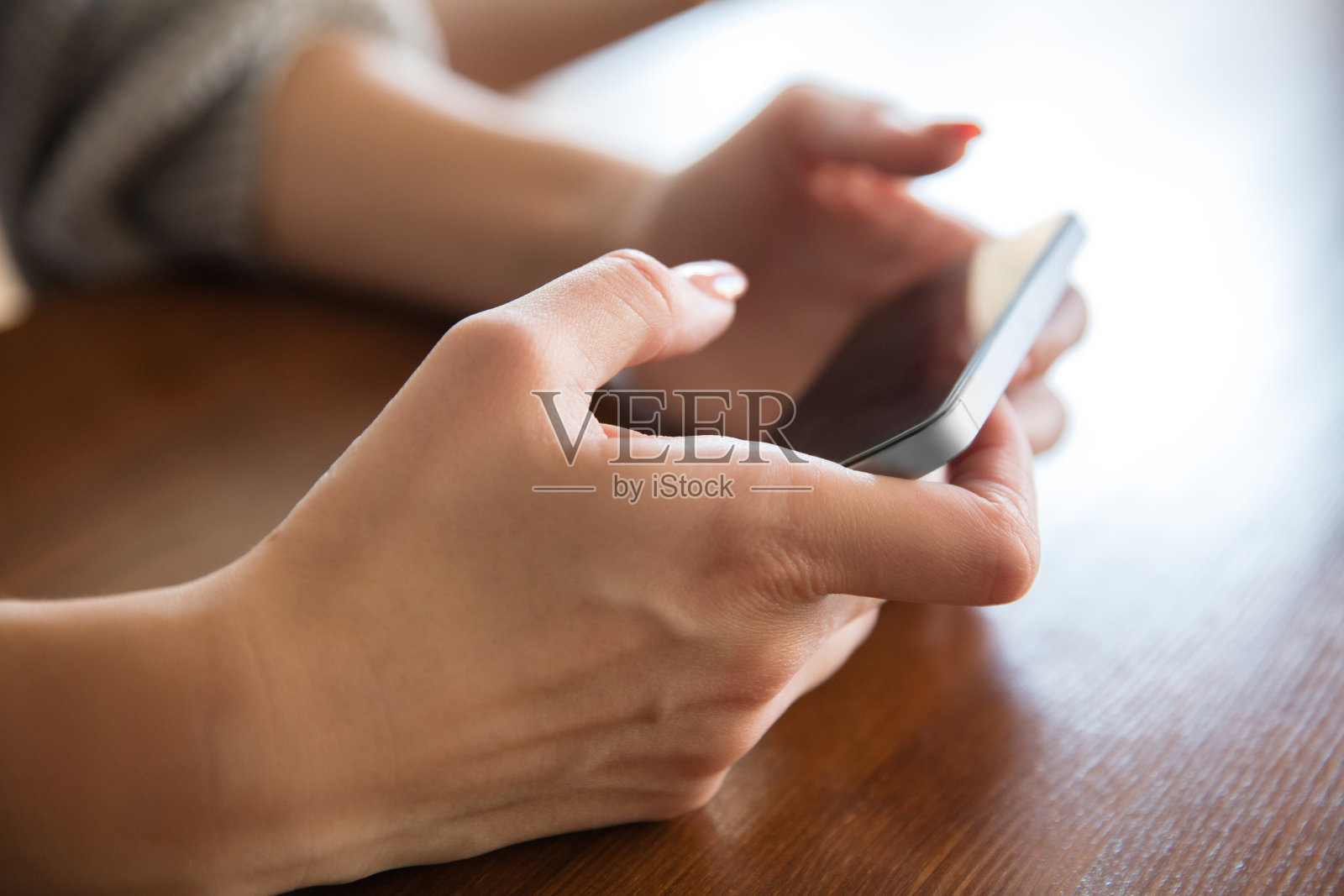 女性手握新款智能手机。照片摄影图片