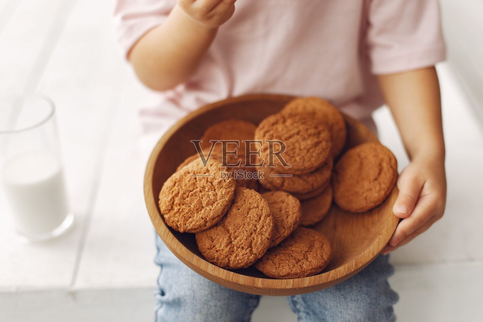 可爱的小女孩坐在工作室里吃饼干照片摄影图片