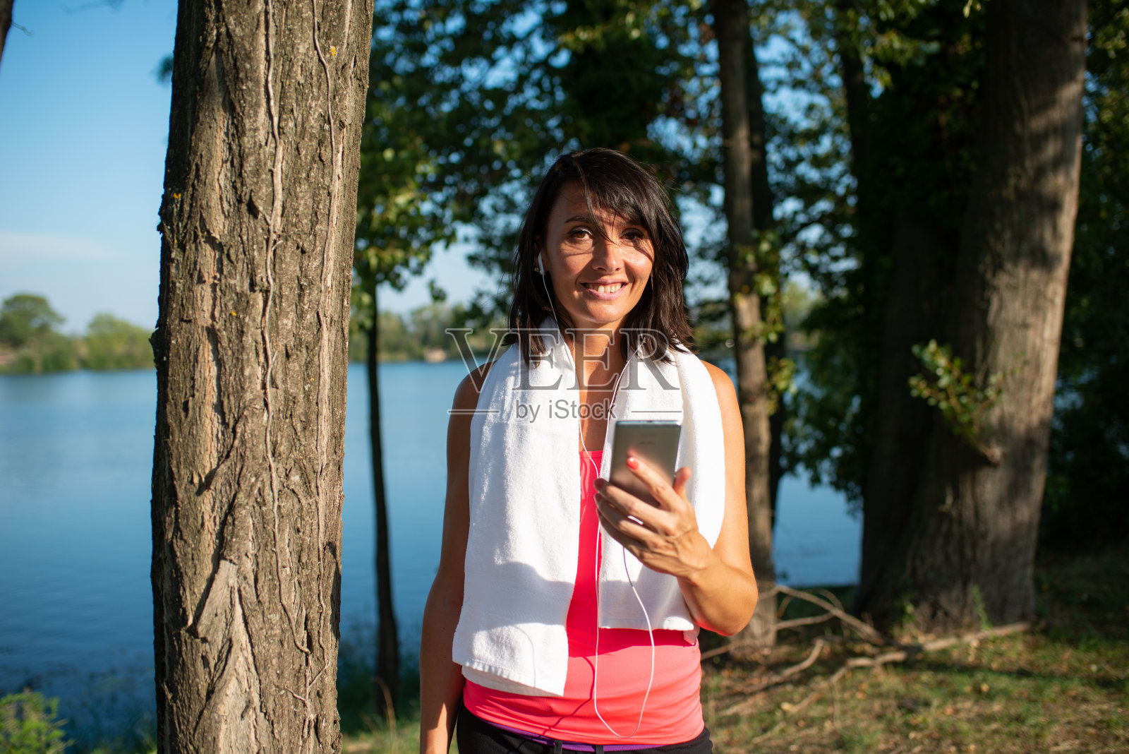 美丽的女人锻炼跑步和户外健身与移动智能手机和运动健康应用程序照片摄影图片