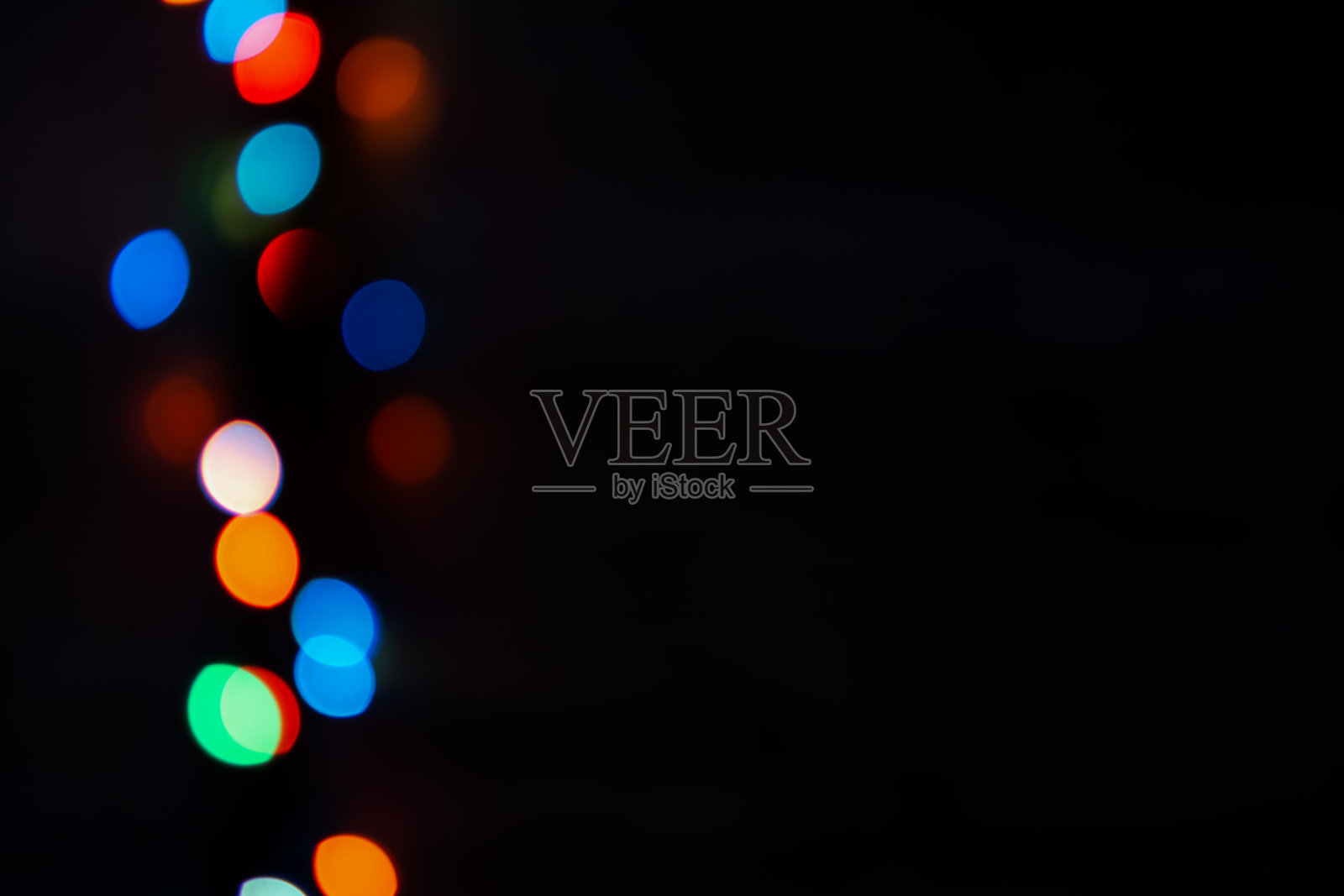 黑色背景上的多色散景。明亮模糊的节日灯光纹理。照片摄影图片