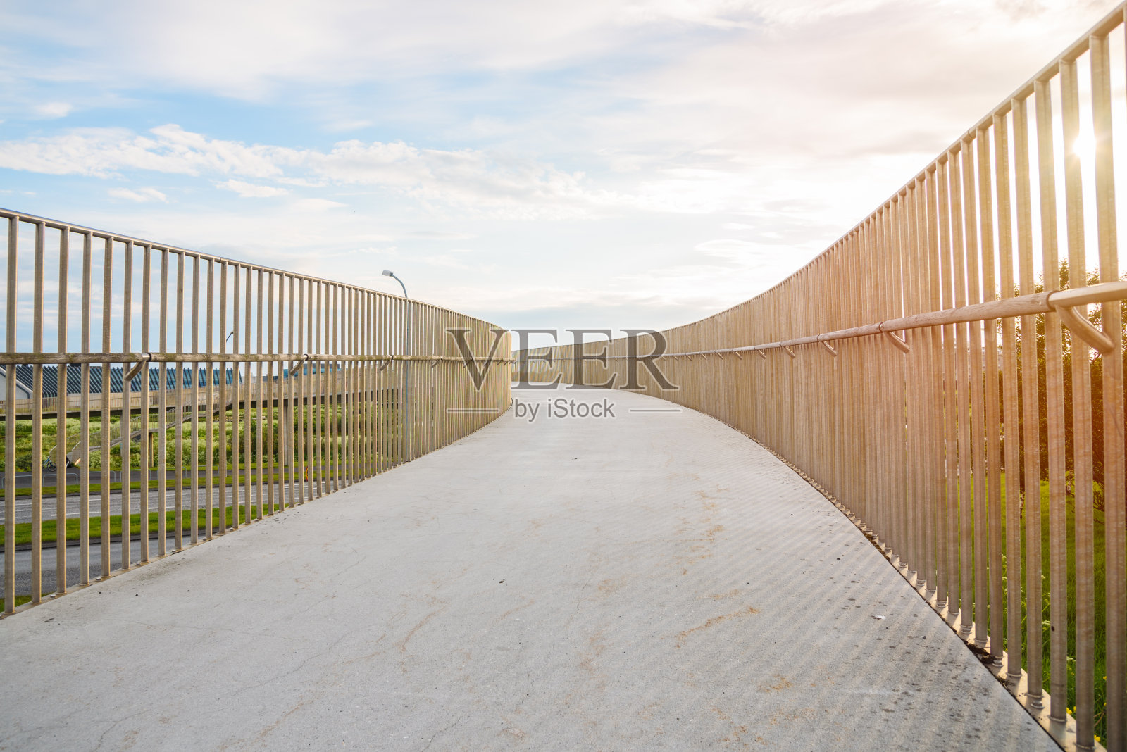 在日落时，行人和骑自行车的人都可以在废弃的弯曲桥上行走照片摄影图片