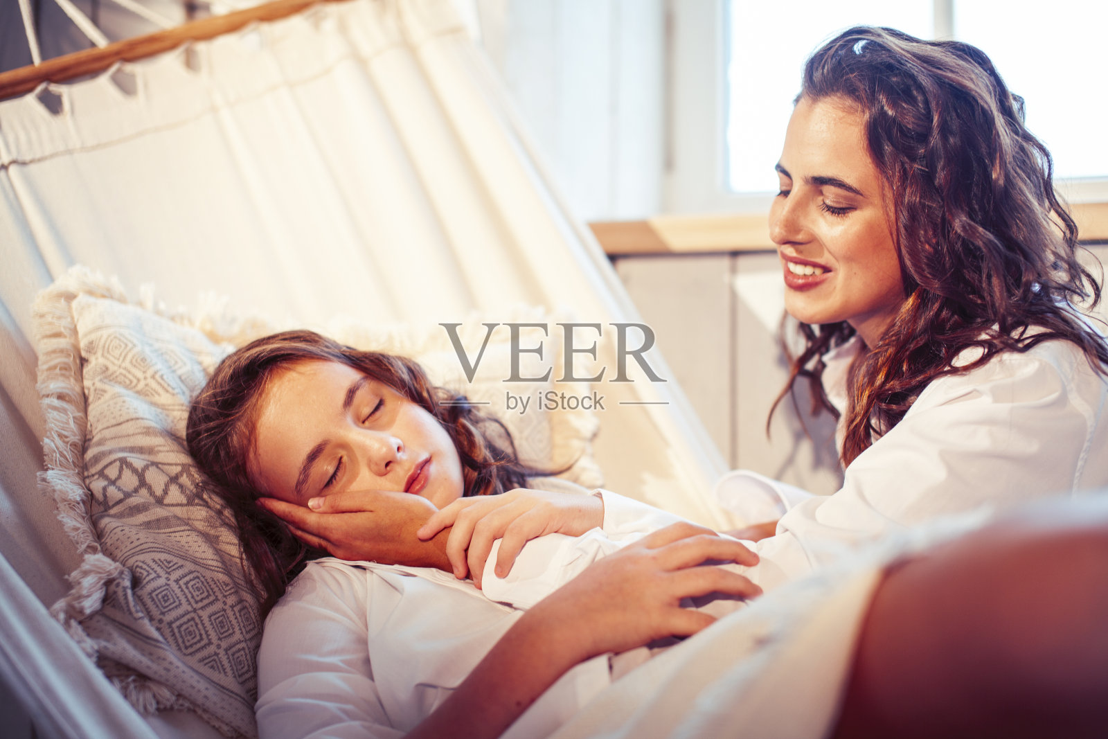 年轻漂亮的姐妹们一大早就在家里的吊床上，休闲的生活方式让人遐想照片摄影图片