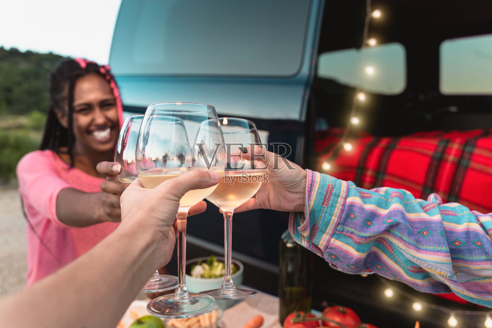 快乐的朋友在货车外吃素食晚餐时欢呼和喝酒-专注于玻璃照片摄影图片