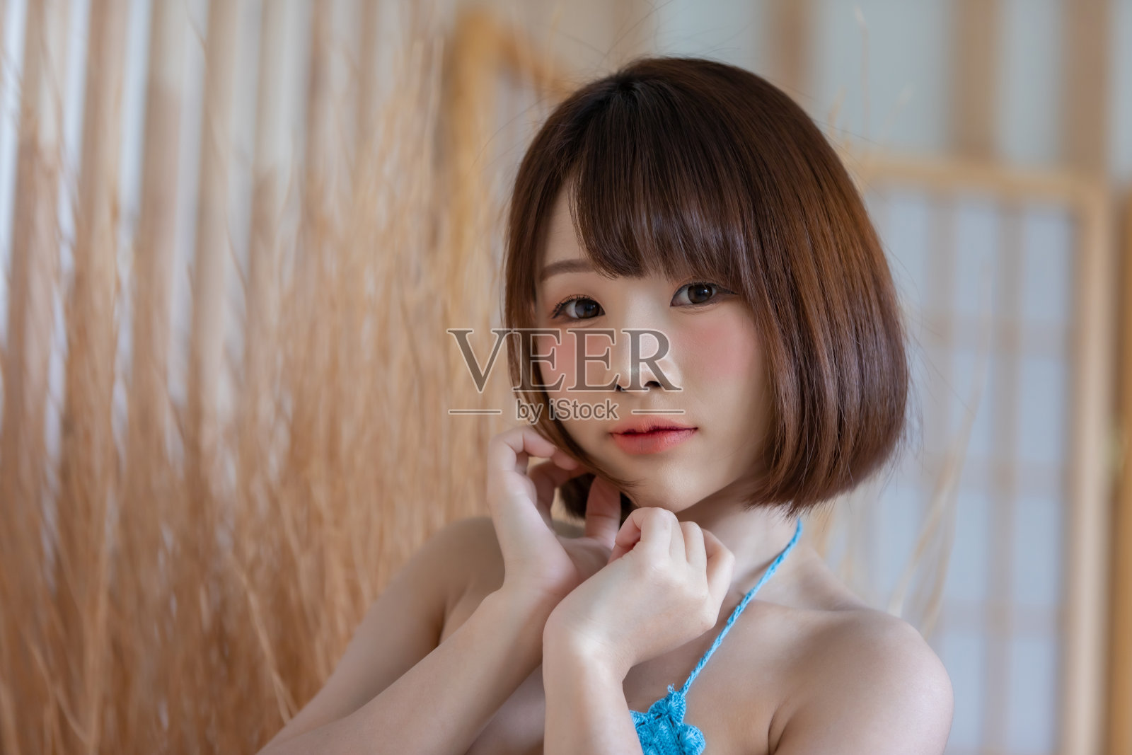 年轻漂亮的亚洲女人的肖像穿着蓝色比基尼在她的房间。照片摄影图片