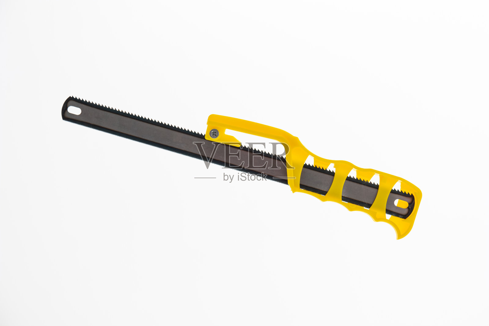 黄色塑料柄的手工小木锯。近距离隔离白色。照片摄影图片