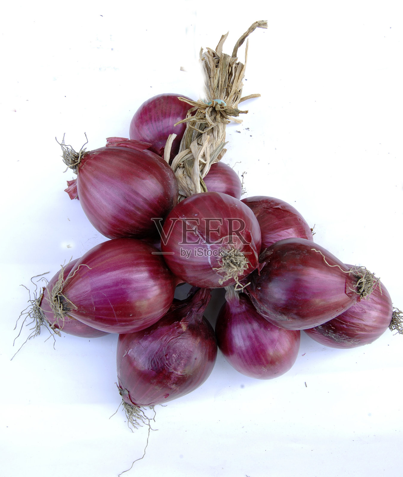 一束孤立在白色背景上的特罗培红洋葱。照片摄影图片