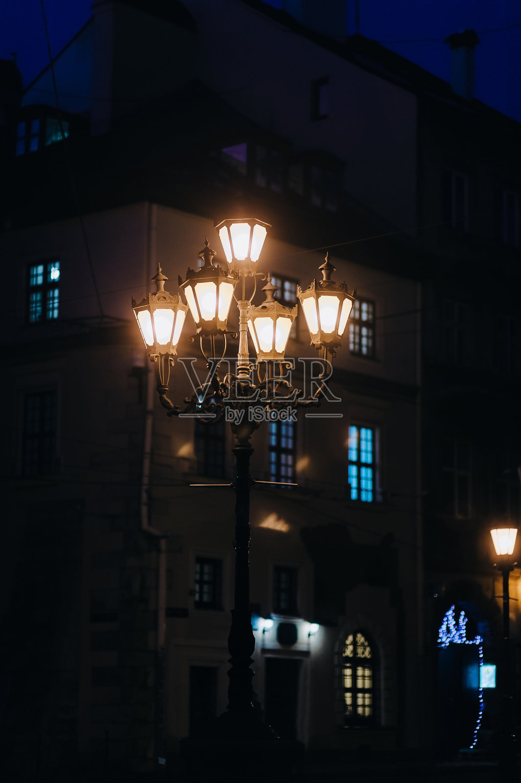 一盏古老而美丽的灯笼在夜色中闪耀着温暖的光芒，利沃夫。夜晚城市的概念，历史的部分。照片摄影图片