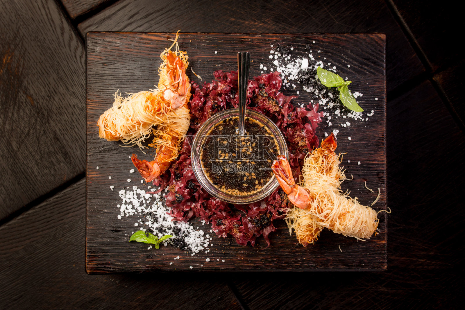 天妇罗大虾配酱油和香草放在深色木板上照片摄影图片