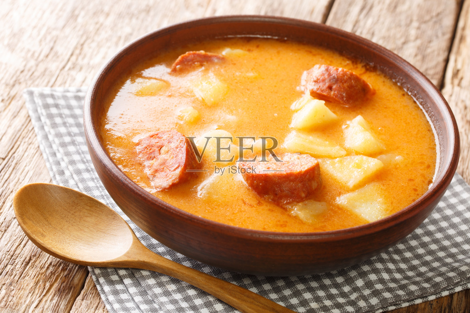 自制土豆汤，配香肠和酸奶油，放在盘子里特写。水平照片摄影图片