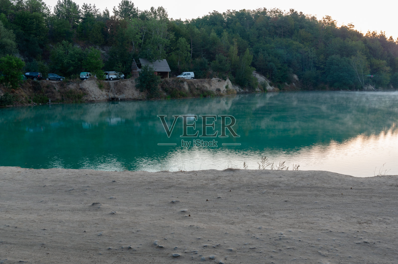 自然绿色的湖。旅游营地湖区。湖边有许多汽车。照片摄影图片
