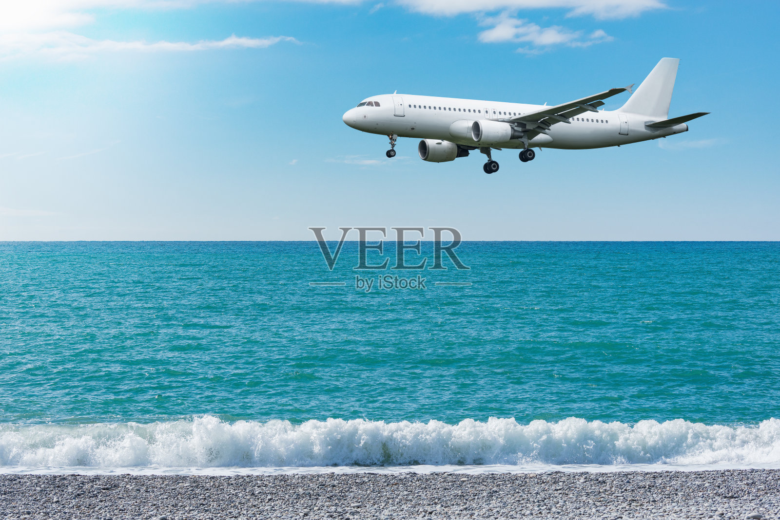 在着陆前在海面上飞行的飞机。照片摄影图片