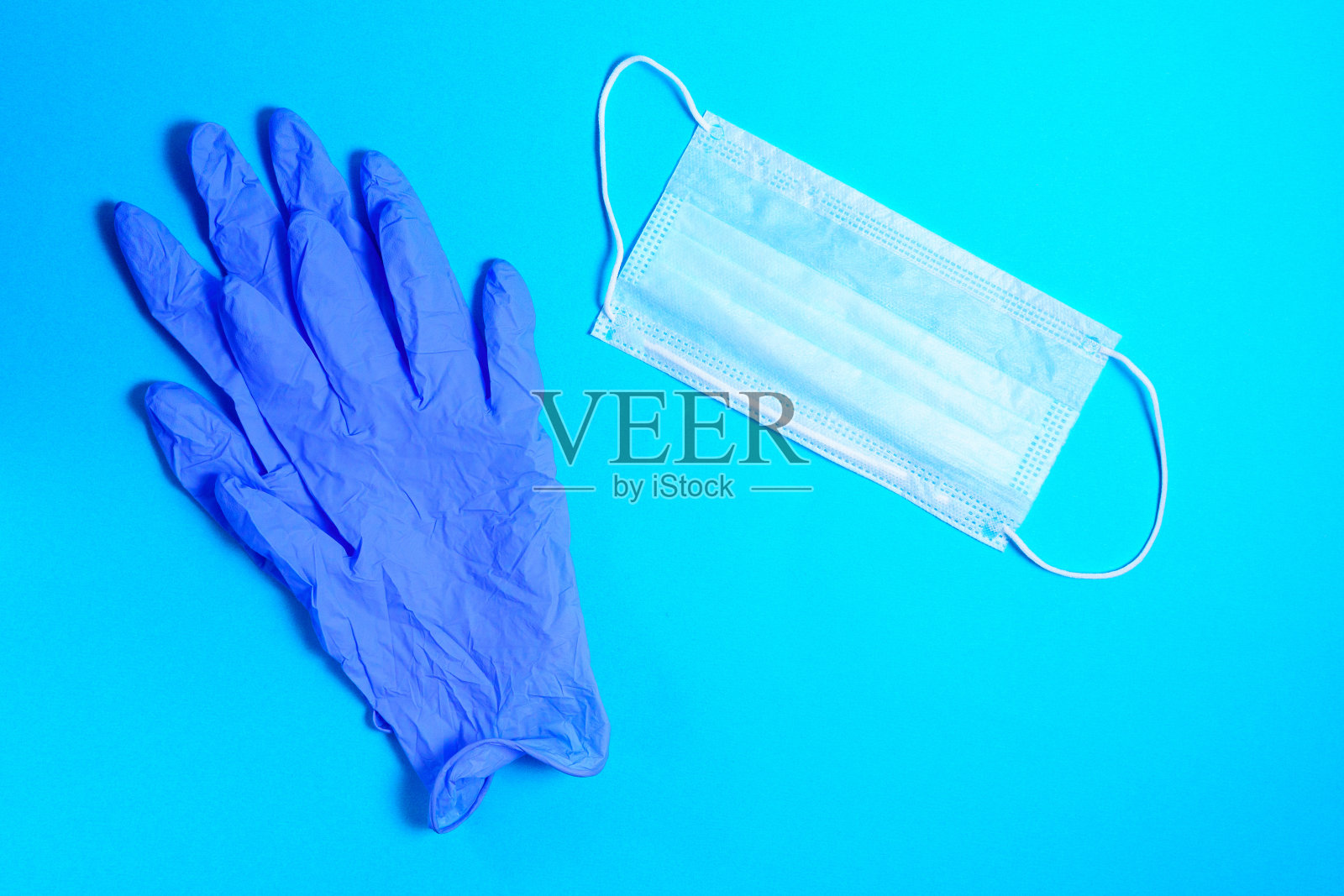 医用防护口罩，橡胶手套，蓝色背景。防蛀牙19病毒防护套件。从上往下看照片摄影图片
