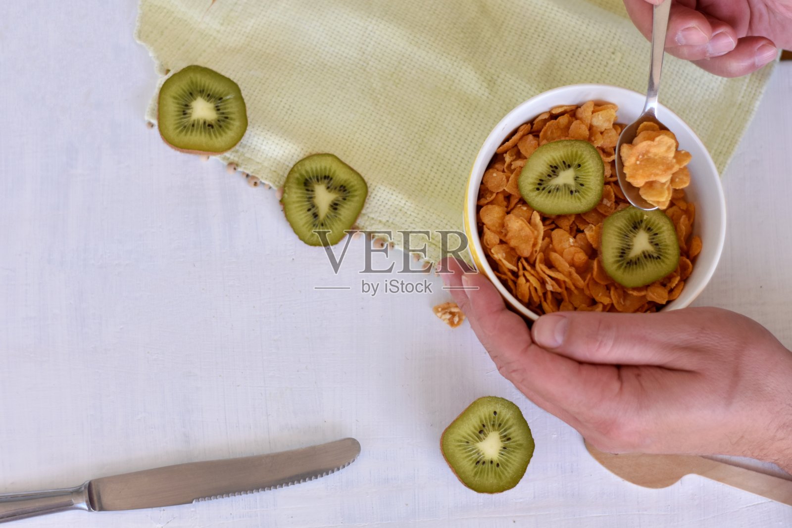 健康营养/人吃美味的格兰诺拉麦片早餐，酸奶和猕猴桃在白色的木制背景上照片摄影图片