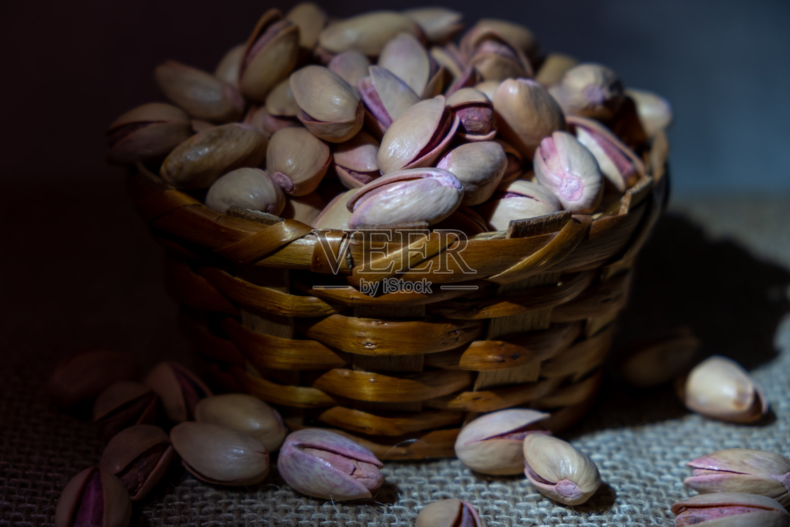 小篮子里的开心果干放在桌子上，有复印空间。谷物对健康。照片摄影图片