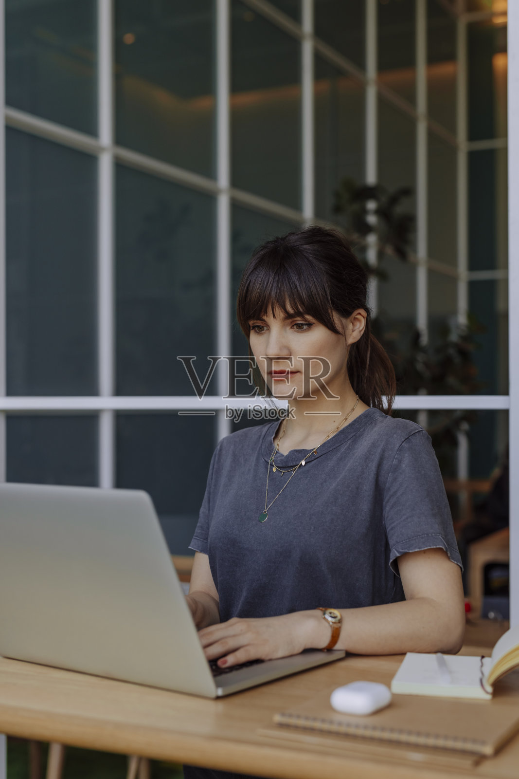 商界女性:一位年轻的女商人在她的办公室使用笔记本电脑照片摄影图片