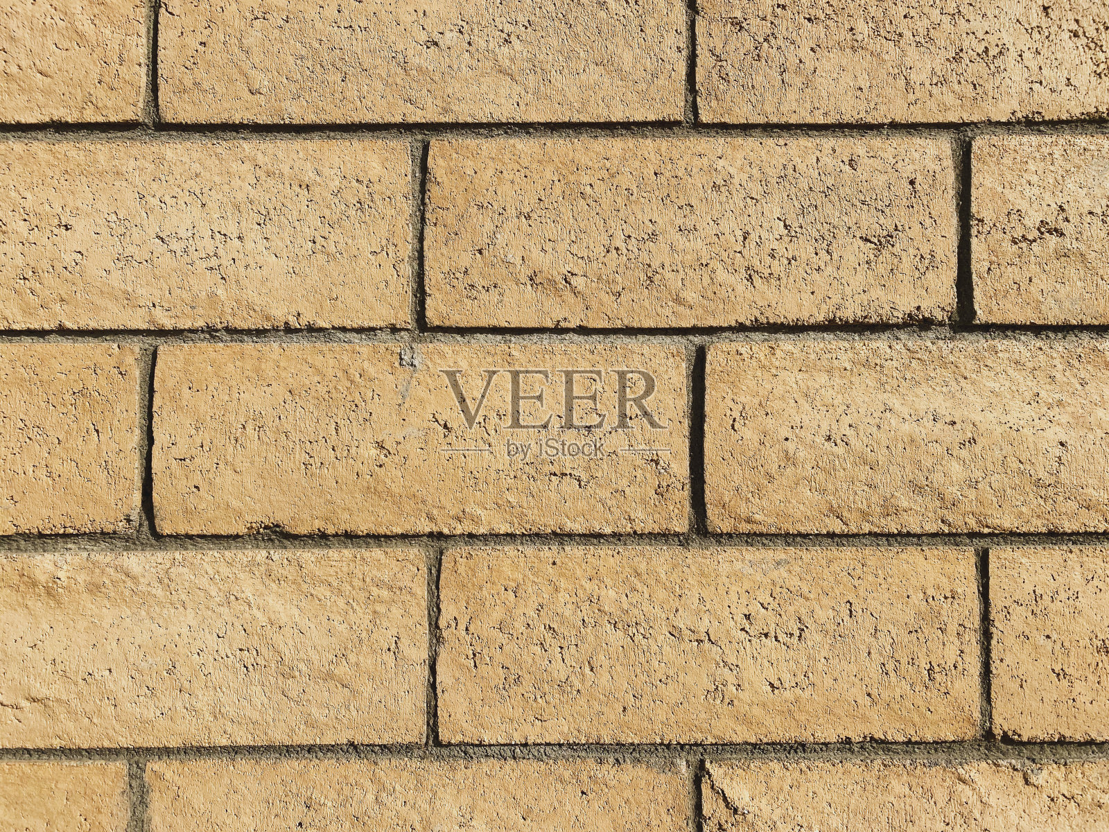 棕褐色砖砌块墙的近景显示浆液细节，水平线设计与明亮的自然阳光增强粗糙的细节和纹理照片摄影图片