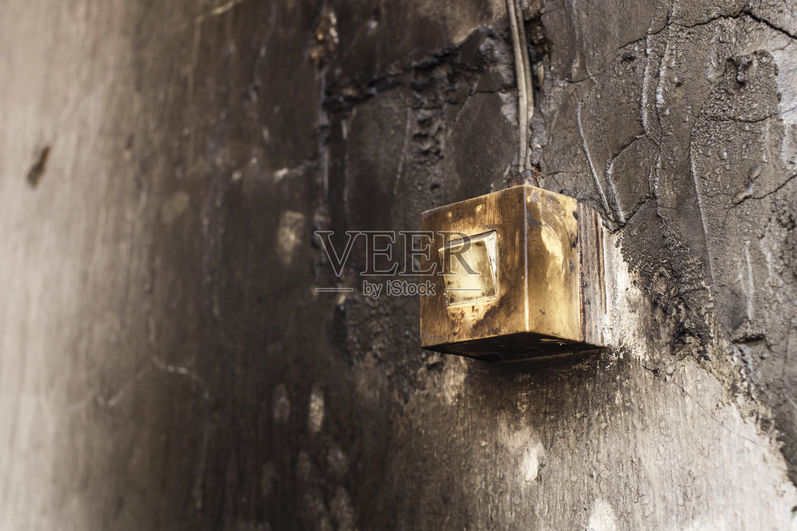 由于冷凝，潮湿的墙壁上的旧开关和糟糕的布线，前景和背景因散景效果而模糊照片摄影图片