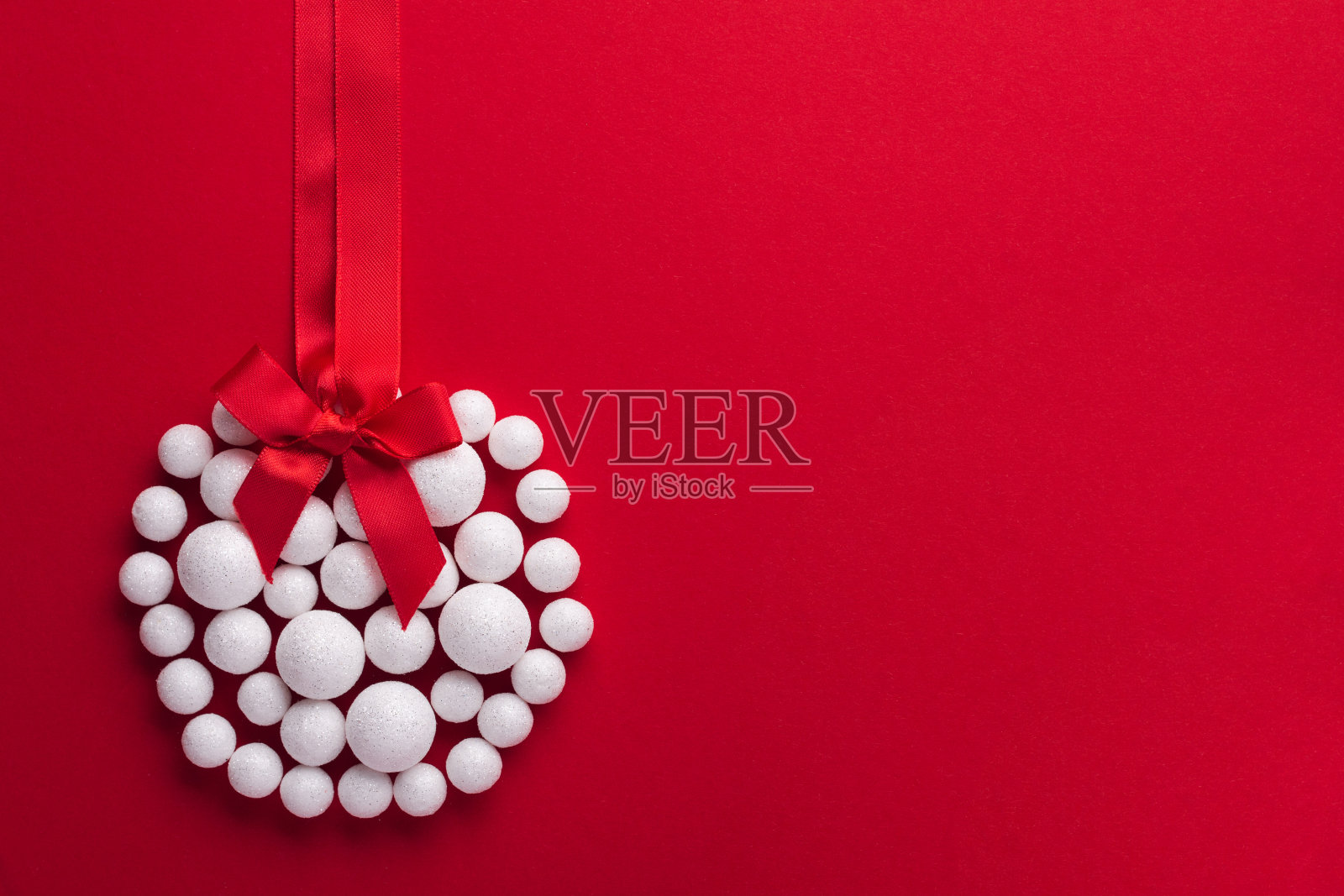 圣诞玩具球由装饰白色的雪在红色的圣诞背景。节日构图平铺。照片摄影图片