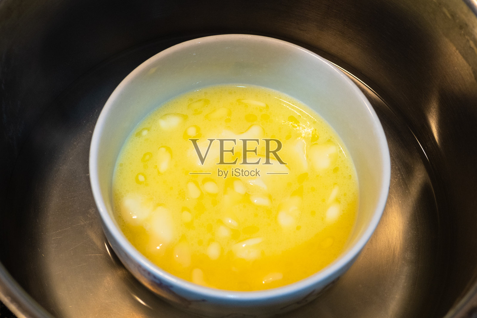 将黄油放入碗中，放入水浴中照片摄影图片