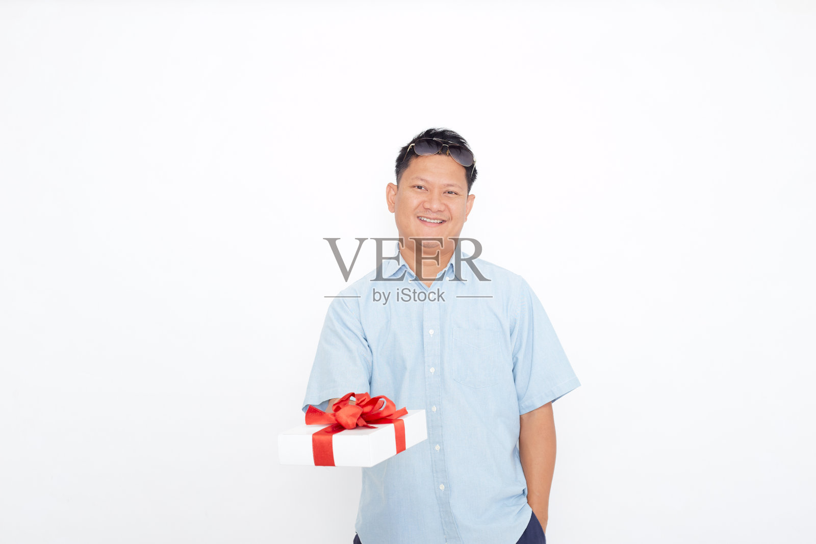 微笑英俊的亚洲男人拿着礼盒照片摄影图片