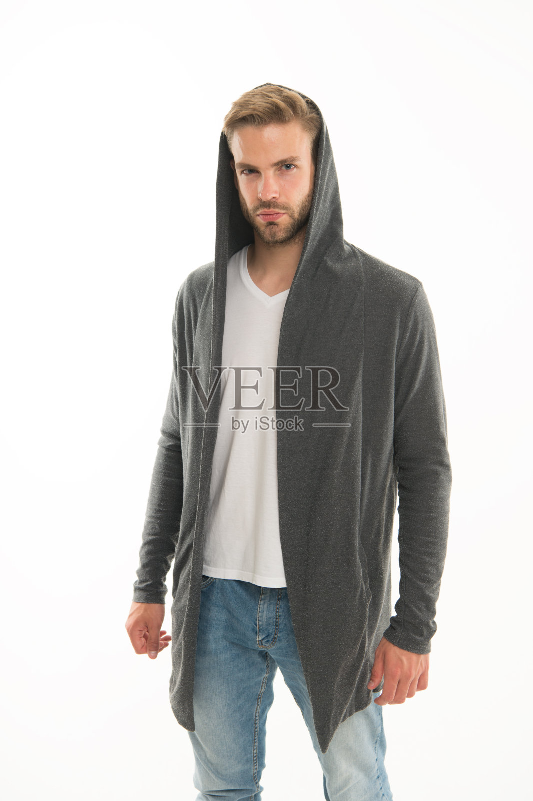 时尚的趋势。街头风格的衣服。英俊的男子与兜帽站在白色的背景。每天穿衣服。男装的概念。休闲和舒适。男性时尚影响者。时尚模特的人照片摄影图片