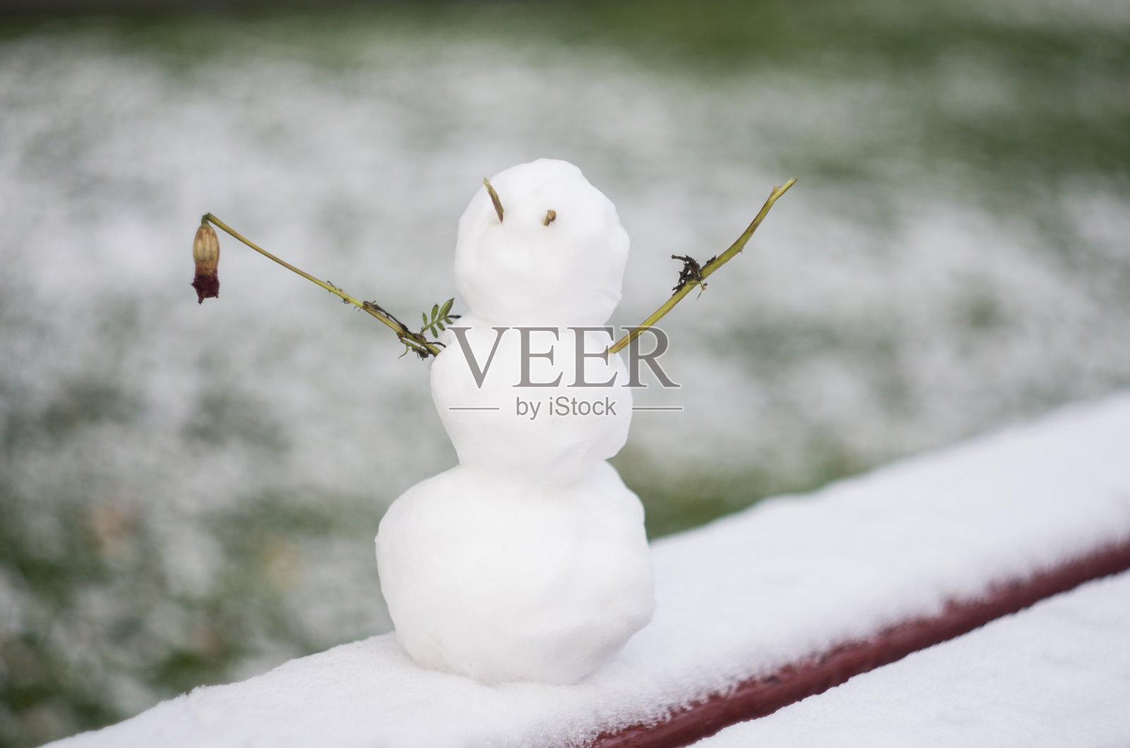 长凳上的丑陋小雪人。冬天的雪人，背景照片摄影图片