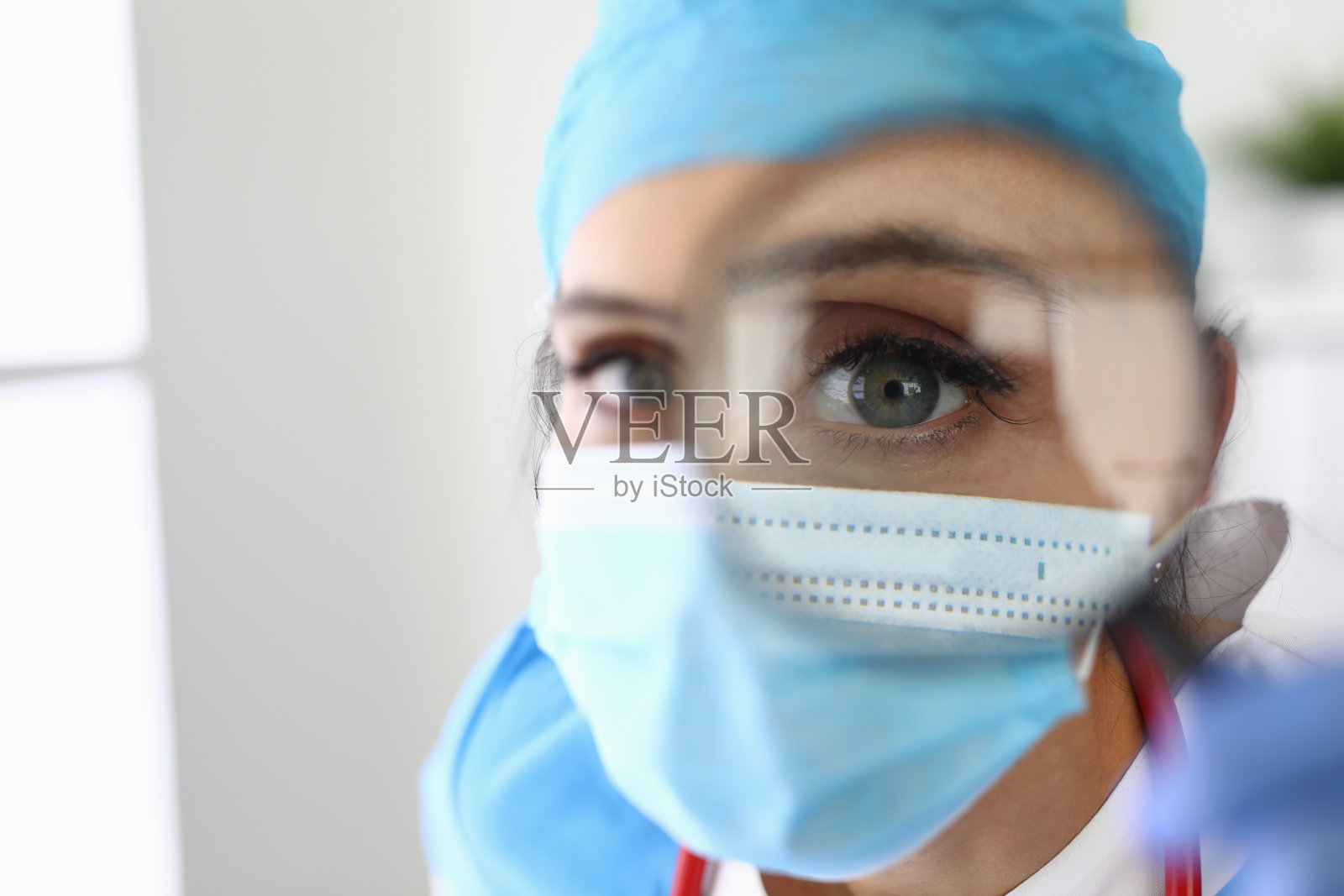 蒙面医生通过放大镜观察特写照片摄影图片