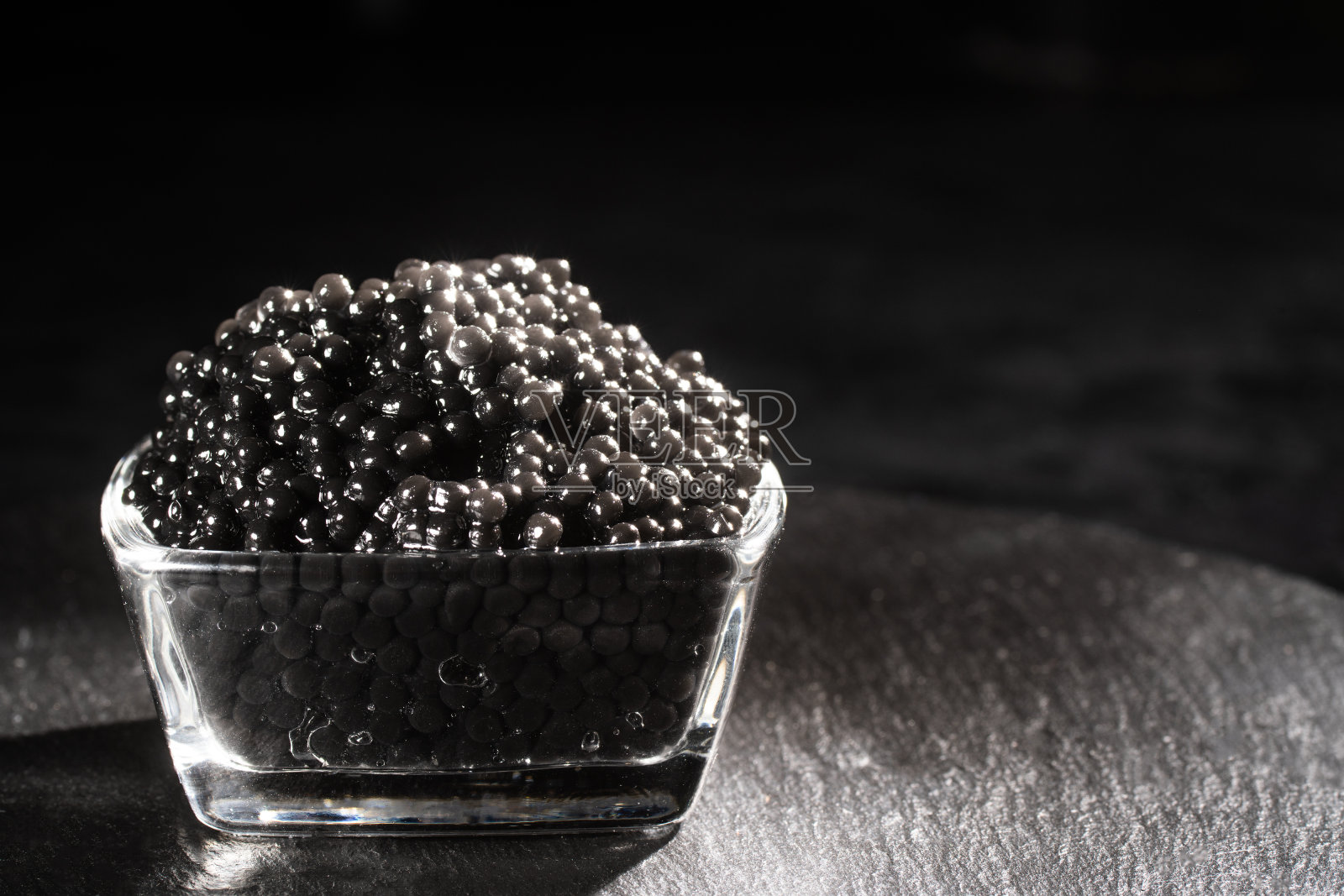 黑鱼子酱的背景。高品质真正的天然鲟鱼黑鱼子酱特写。照片摄影图片