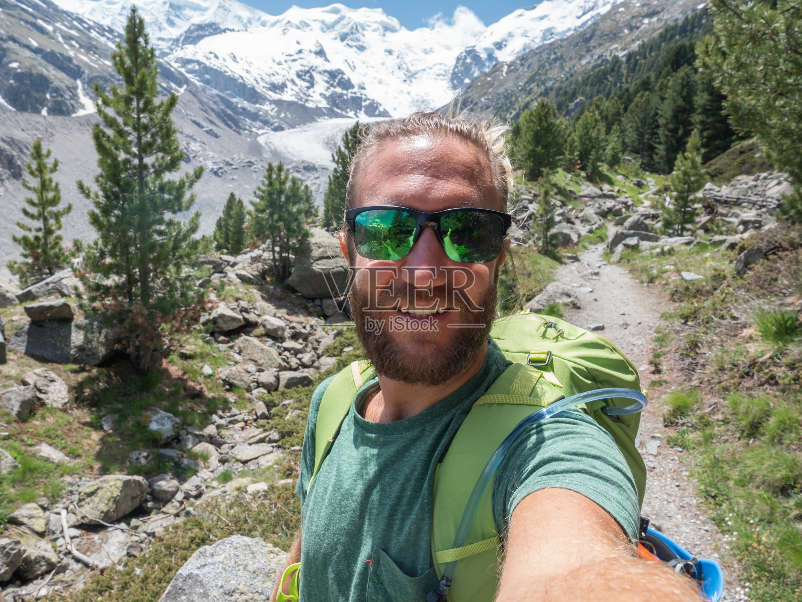 徒步男在远处的山脉、冰川中自拍照片摄影图片