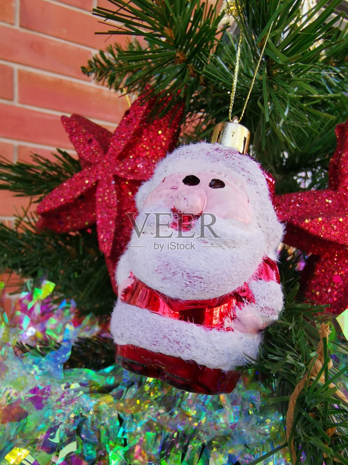 圣诞老人挂在绿色的圣诞树上照片摄影图片