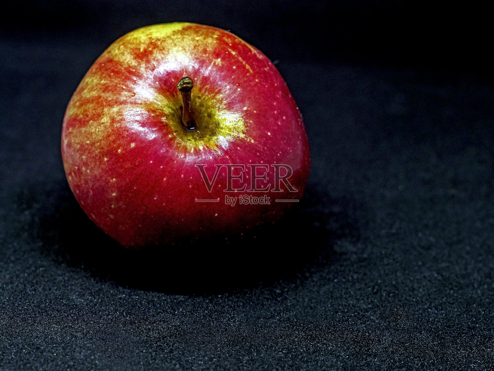 一个明亮的红色苹果在黑色的背景，微距照片摄影图片