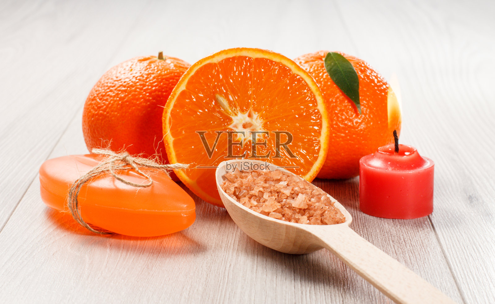 用两个完整的橘子，肥皂，木勺和海盐和燃烧的蜡烛切橘子照片摄影图片