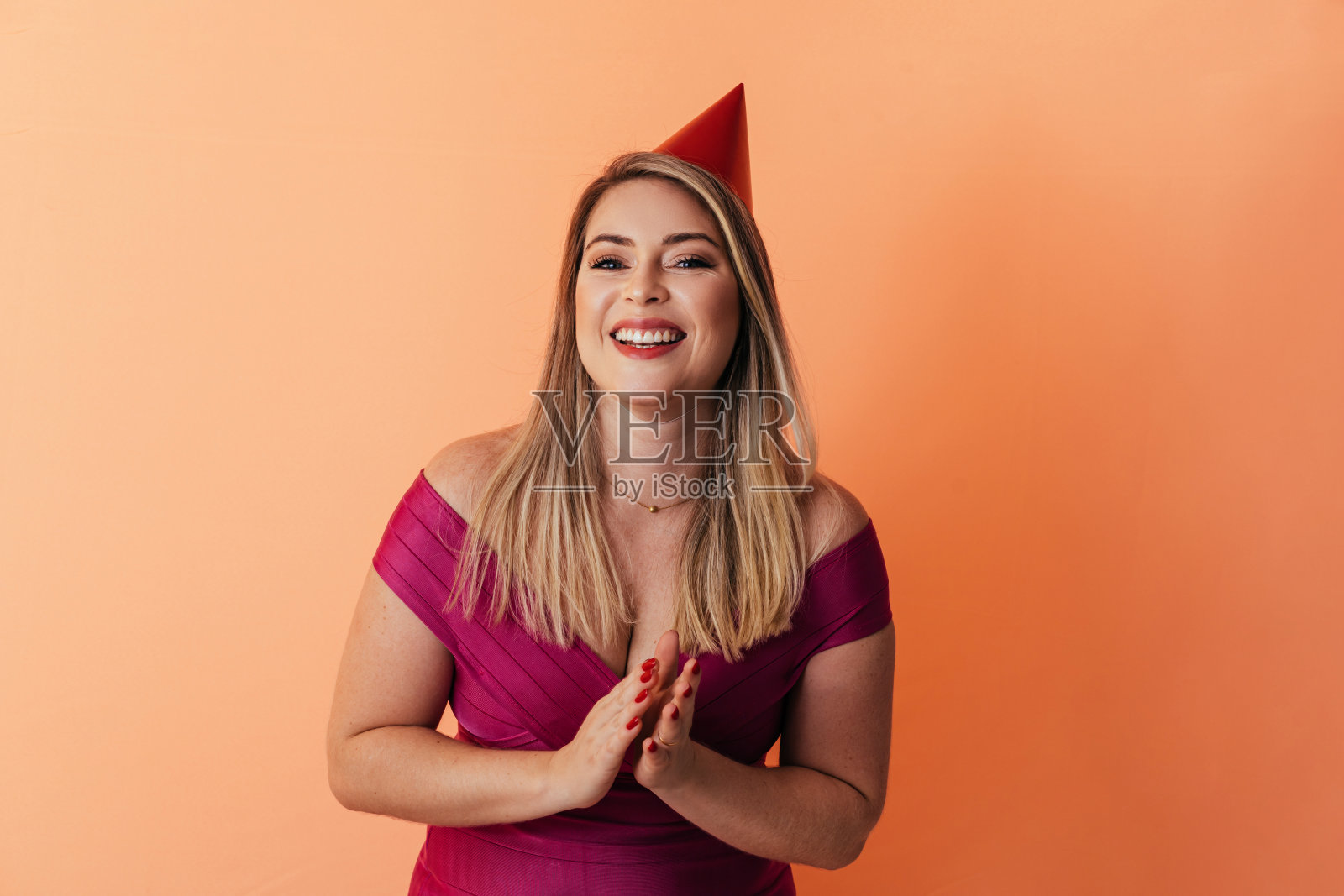 肖像的年轻女子戴派对帽子在彩色的背景照片摄影图片