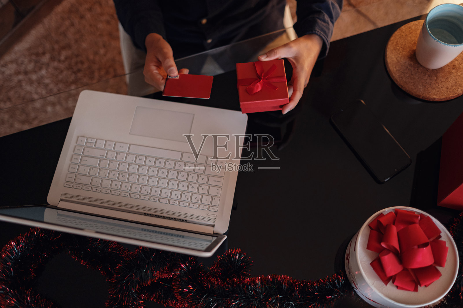 快乐的人戴着圣诞老人的帽子拿着礼物或信用卡照片摄影图片