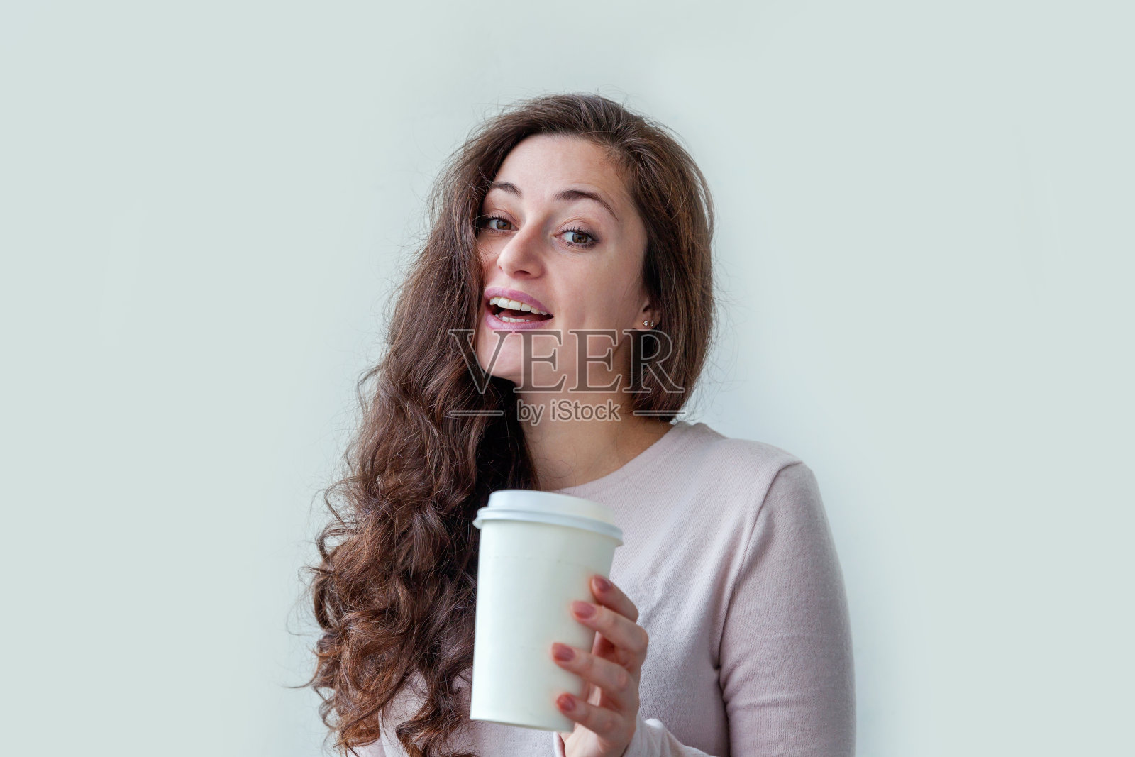 美丽年轻的黑发女人与带走的纸咖啡杯孤立在白色的背景。快乐微笑的女孩正在吃午饭。早上喝饮料休息休闲的概念照片摄影图片