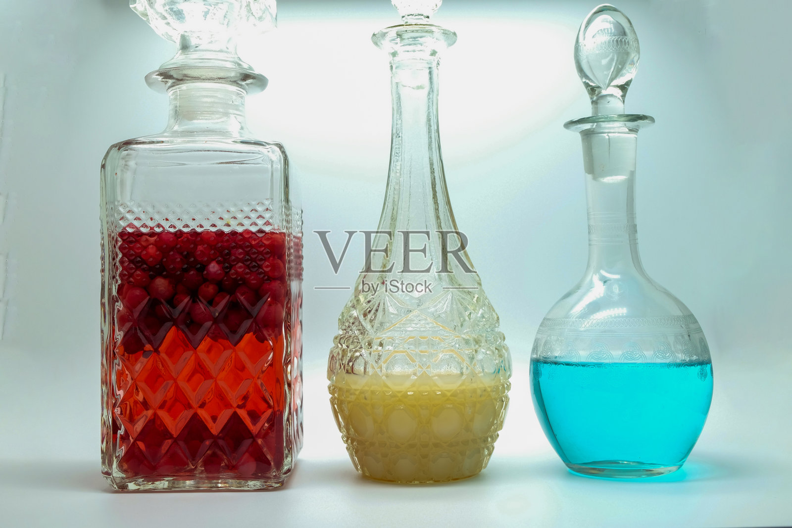 三瓶颜色鲜亮的水果柠檬水，蓝红黄特别涂漆的酒吧饮料照片摄影图片