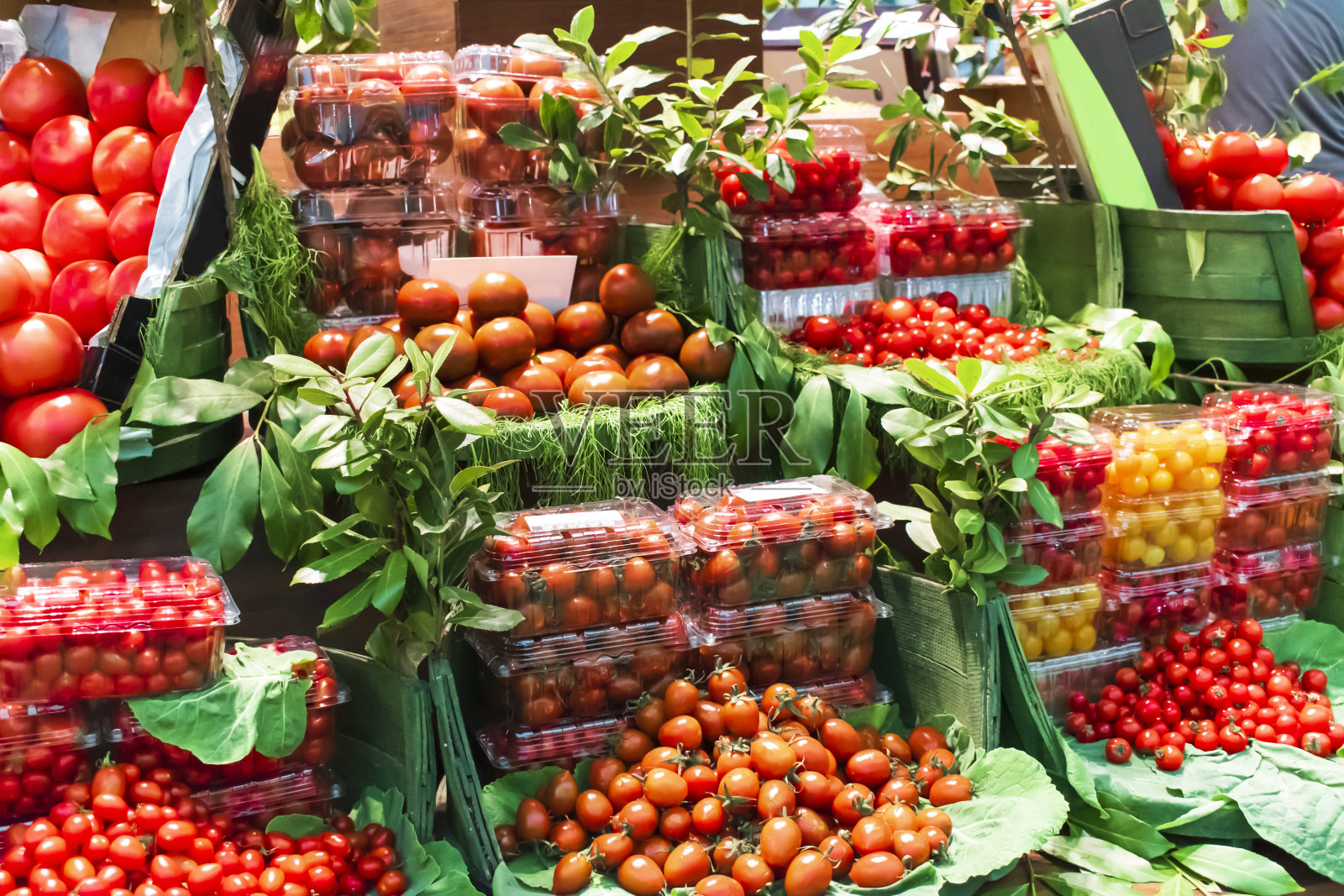 柜台上的有机番茄。市场柜台上的各种西红柿。新鲜有机圣女果。照片摄影图片