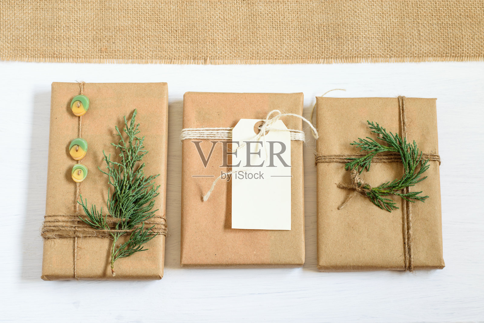 手工制作的礼品盒包装在牛皮纸和打结，装饰节日。不错的零浪费模拟设计为圣诞节或其他节日。Diy的概念。照片摄影图片