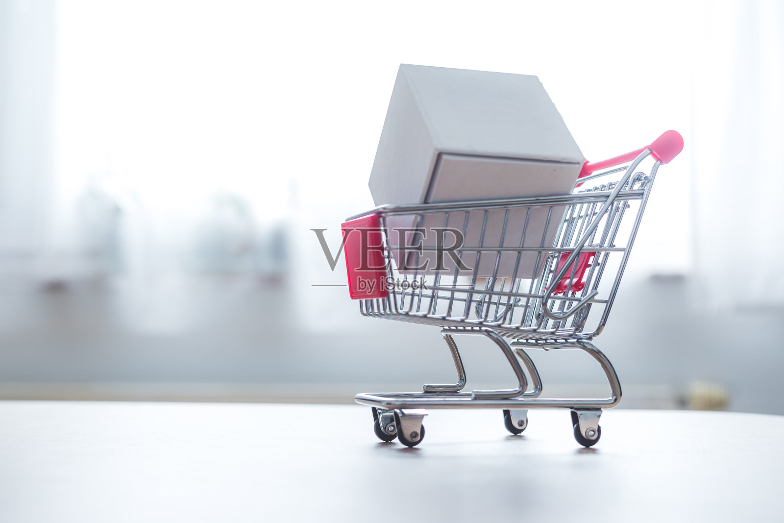 网上购物的概念:白色盒子上的小购物车照片摄影图片