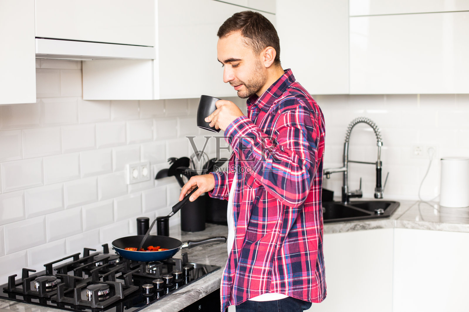 单身帅哥独自在家煎锅里放橄榄油植物油照片摄影图片