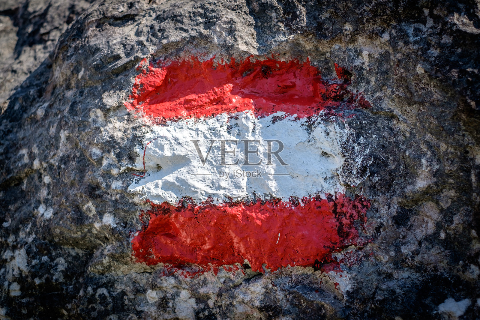 红色游客或徒步旅行路线标志石头上的标志。照片摄影图片