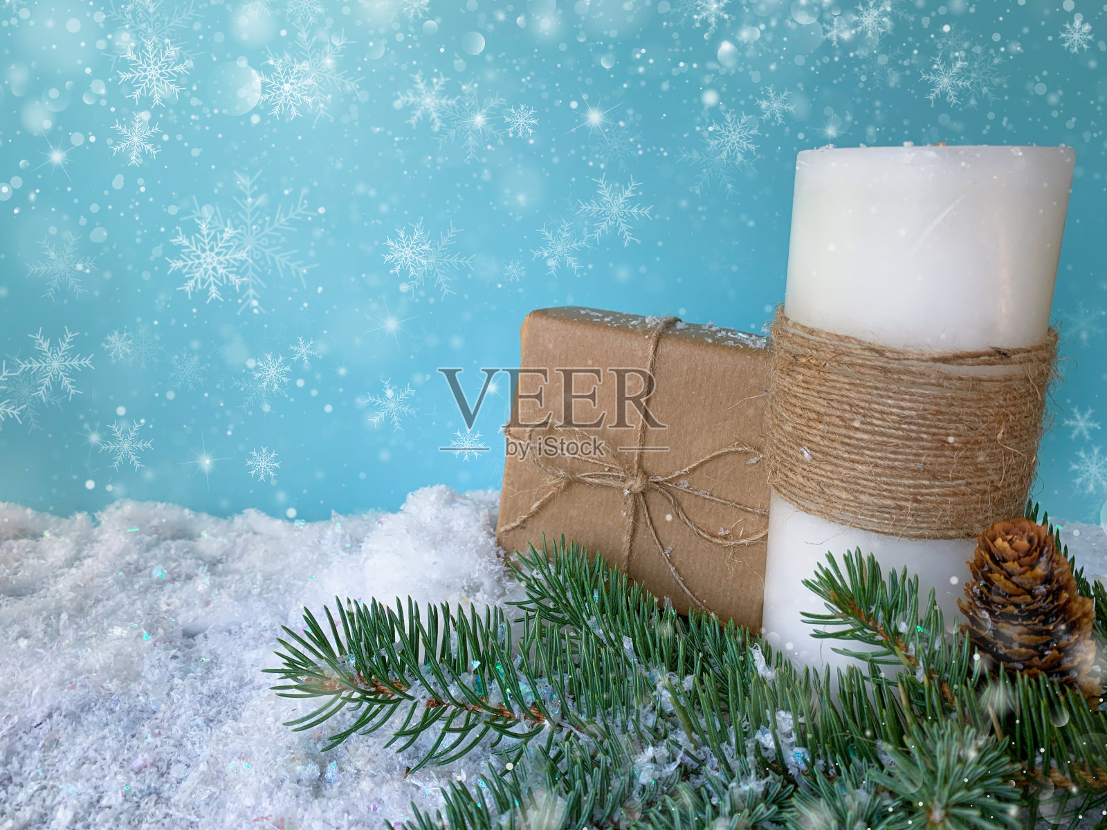 雪花圣诞背景与牛皮纸礼盒，云杉枝和白色节日蜡烛。照片摄影图片