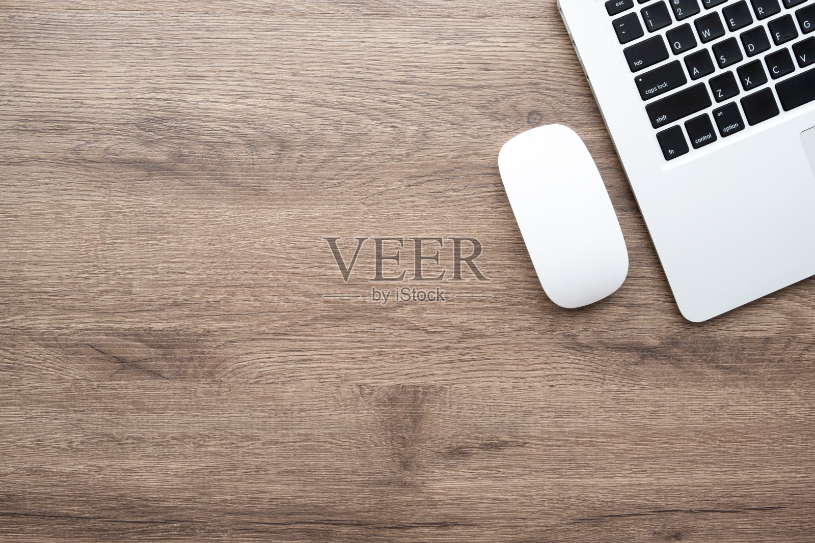 木制办公桌，桌上有笔记本电脑和白色无线鼠标。顶视图与复制空间，平放。照片摄影图片