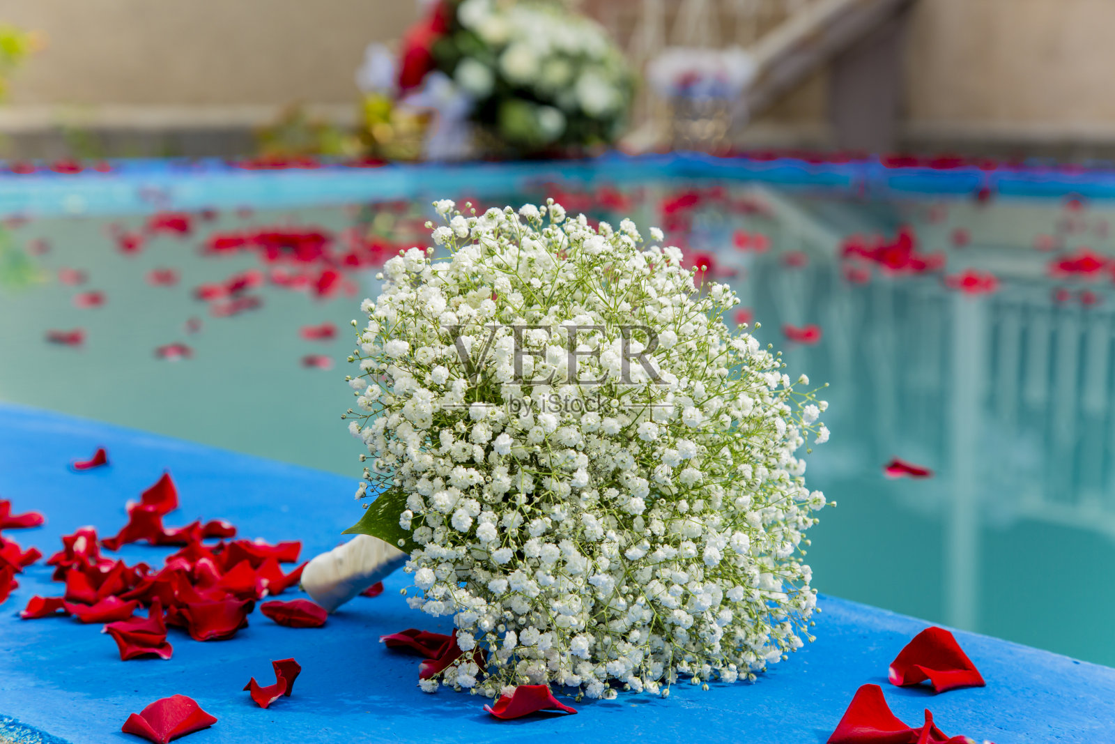 游泳池里的婚礼桶，上面有天然的玫瑰花瓣照片摄影图片